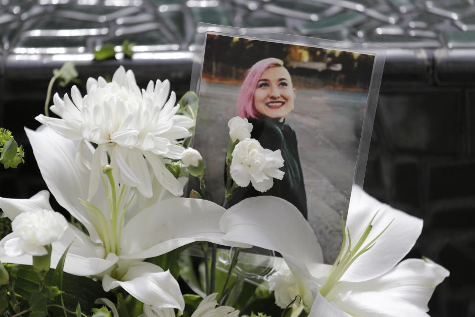 A photo of Summer Taylor, who suffered critical injuries and died after being hit by a car while protesting over the weekend, sits among flowers at the King County Correctional Facility where a hearing was held for the suspect in their death Monday, July 6, 2020, in Seattle. Dawit Kelete is accused of driving a car on to a closed Seattle freeway and hitting two protesters, killing one, over the weekend. Seattle has been the site of prolonged unrest over the death of George Floyd, a Black man who was in police custody in Minneapolis, and had shut down the interstate for 19 days in a row. (AP Photo/Elaine Thompson)