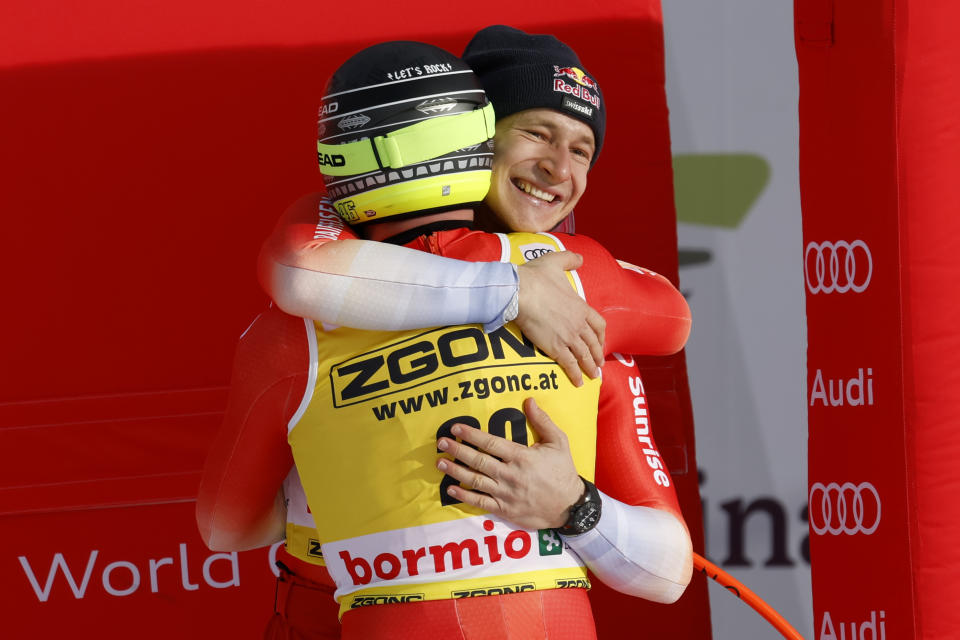 Switzerland's Marco Odermatt, right, hugs Switzerland's Justin Murisier at the finish area of an alpine ski, men's World Cup downhill race, in Bormio, Italy, Thursday, Dec. 28, 2023. (AP Photo/Alessandro Trovati)