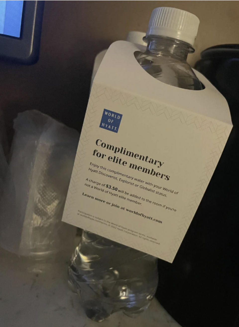 Water bottle with a tag reading: "Complimentary for elite members. Enjoy this water with your World of Hyatt status. A $5 charge will apply otherwise."