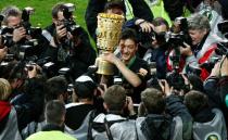 FILE PHOTO: Werder Bremen's Mesut Ozil celebrates with the German Cup after scoring the only goal to secure a 1-0 win in the final against Bayer Leverkusen in Berlin.