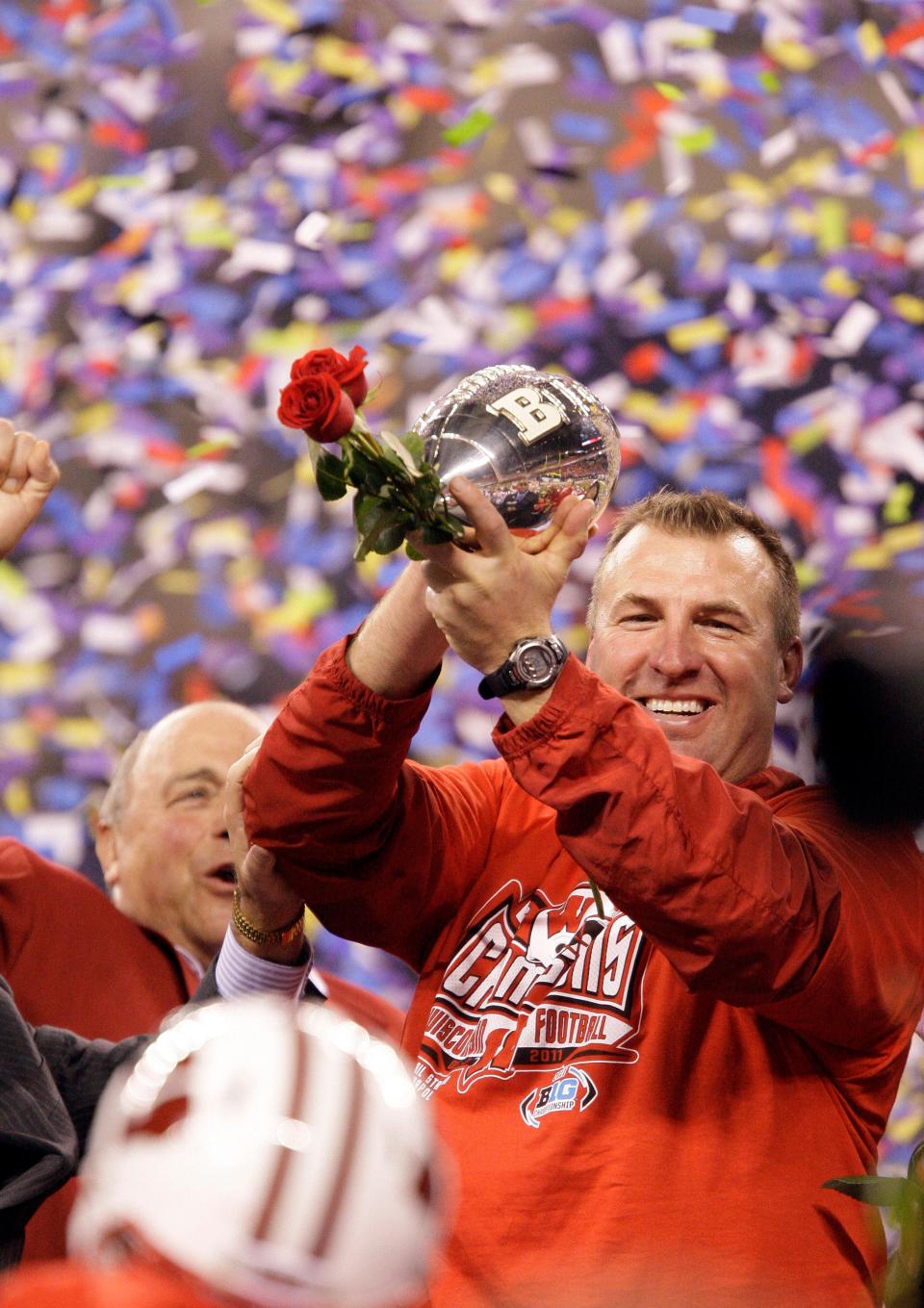 Wisconsin Badger head coach Bret Bielema holds the Big Ten title trophy after winning the Big Ten title in 2011.