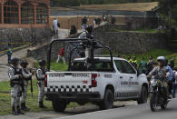 FILE - National Guardsmen guard a site where a confrontation took place with what authorities say were groups of criminals, that left several police officers wounded and more than a dozen people detained, in Tupilejo, on the outskirts of Mexico City, July 12, 2022. Mexico’s President Andres Manuel Lopez Obrador has begun exploring plans to side-step congress to hand formal control of the National Guard to the army. That has raised concerns, because he won approval for creating the force in 2019 by pledging in the constitution that it would be under nominal civilian control and that the army would be off the streets by 2024. (AP Photo/ Marco Ugarte, File)