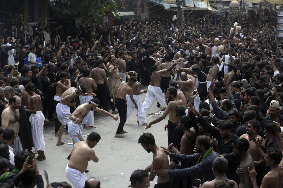 Shiite Muslim flagellate themselves with knifes on chains during a Muharram procession, in Lahore, Pakistan, Monday, Aug. 8, 2022. Muharram, the first month of the Islamic calendar, is a month of mourning for Shiites in remembrance of the death of Hussein, the grandson of the Prophet Muhammad, at the Battle of Karbala in present-day Iraq in the 7th century. (AP Photo/K.M. Chaudary)