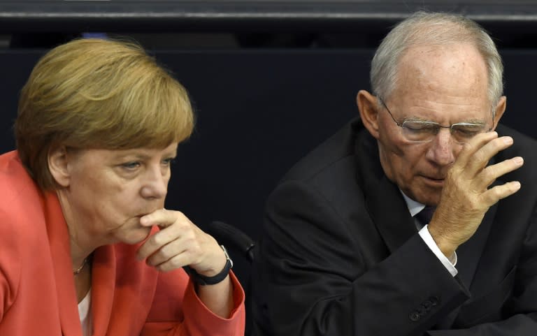 German Chancellor Angela Merkel (L) confers with finance minister Wolfgang Schaeuble during a debate in the Bundestag, the German lower house of parliament, in Berlin