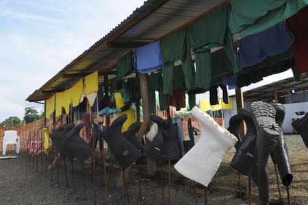 Protection clothes and boots from Medicins Sans Frontieres (MSF) health workers are seen drying outside the isolation unit at ELWA hospital during the visit of Senior United Nations (U.N.) System Coordinator for Ebola David Nabarro (not pictured), in Monrovia August 23, 2014. . REUTERS/2Tango