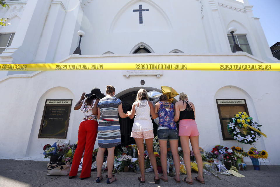 A group of women pray together at a make-shift memorial on the sidewalk in front of the Emanuel AME Church, Thursday, June 18, 2015 in Charleston, S.C.  Dylann Storm Roof, 21, was arrested Thursday in the slayings of several people, including the pastor at a prayer meeting inside the historic black church.
