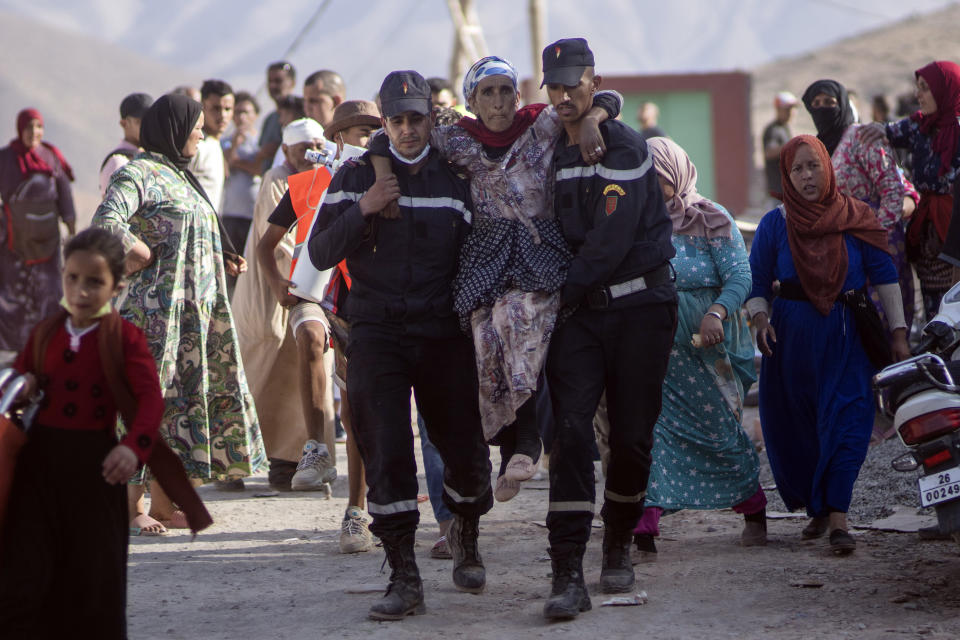 Rescue workers carry a woman who was injured by an aftershock, in the town of Imi N'tala, outside Marrakech, Morocco, Wednesday, Sept. 13, 2023. An aftershock rattled central Morocco on Wednesday, striking fear into rescue crews at work in High Atlas villages, digging people out from rubble that could slide. (AP Photo/Mosa'ab Elshamy)