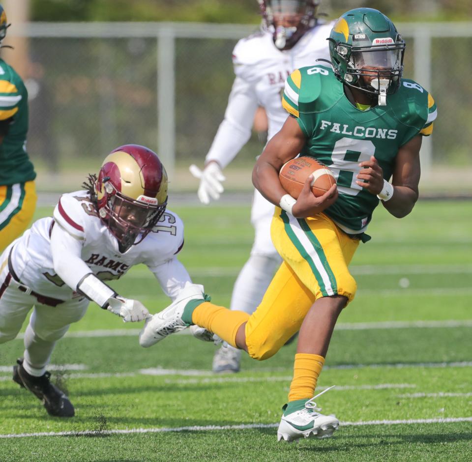 Firestone running back Daniel Peterson gets past the outstretched arms of Garfield linebacker Daveon Logan on Sept. 23 in Akron.