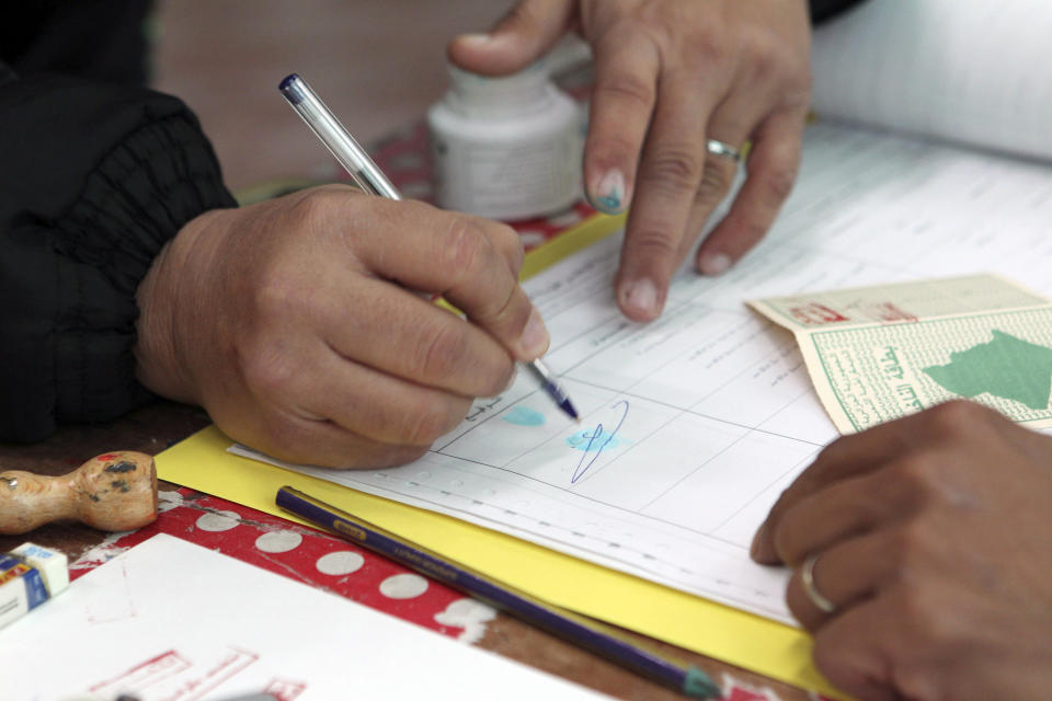 A man casts his vote inside a polling station for the municipality election in Algiers, Algeria, Saturday, Nov. 27, 2021. Algerians are voting to elect their mayors and regional leaders amid widespread worry and frustration over rising prices for basic goods, housing and health care. (AP Photo/ Fateh Guidoum)