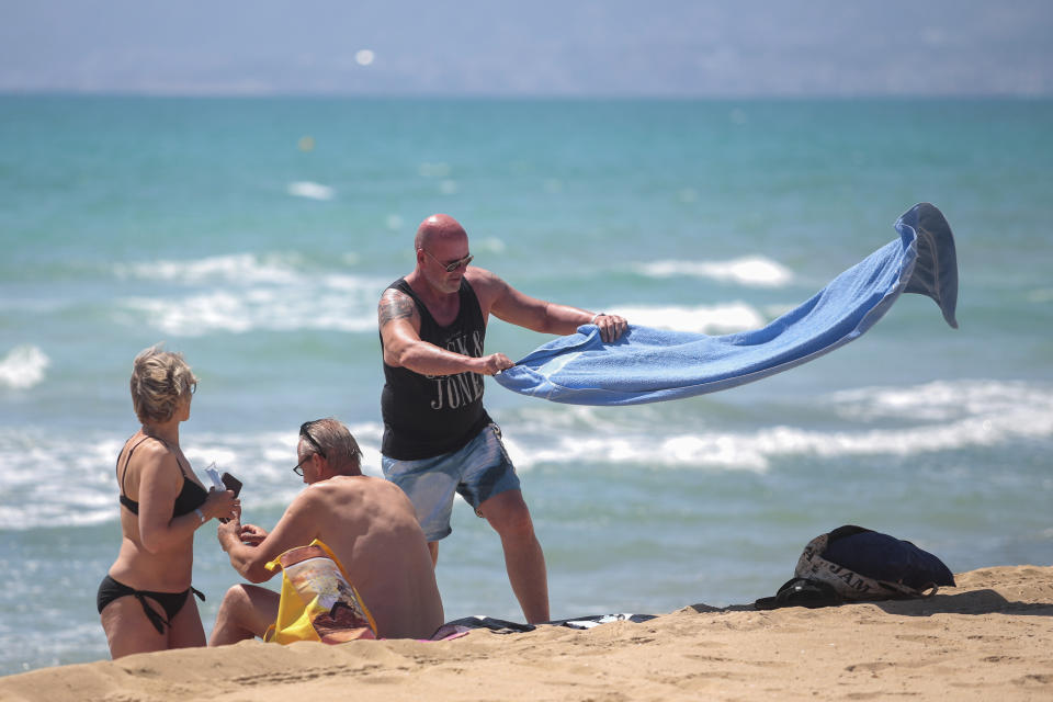 German tourists arrive at the beach of Palma de Mallorca, Spain, Monday, June 15, 2020. Borders opened up across Europe on Monday after three months of coronavirus closures that began chaotically in March. But many restrictions persist, it's unclear how keen Europeans will be to travel this summer and the continent is still closed to Americans, Asians and other international tourists. (AP Photo/Joan Mateu)