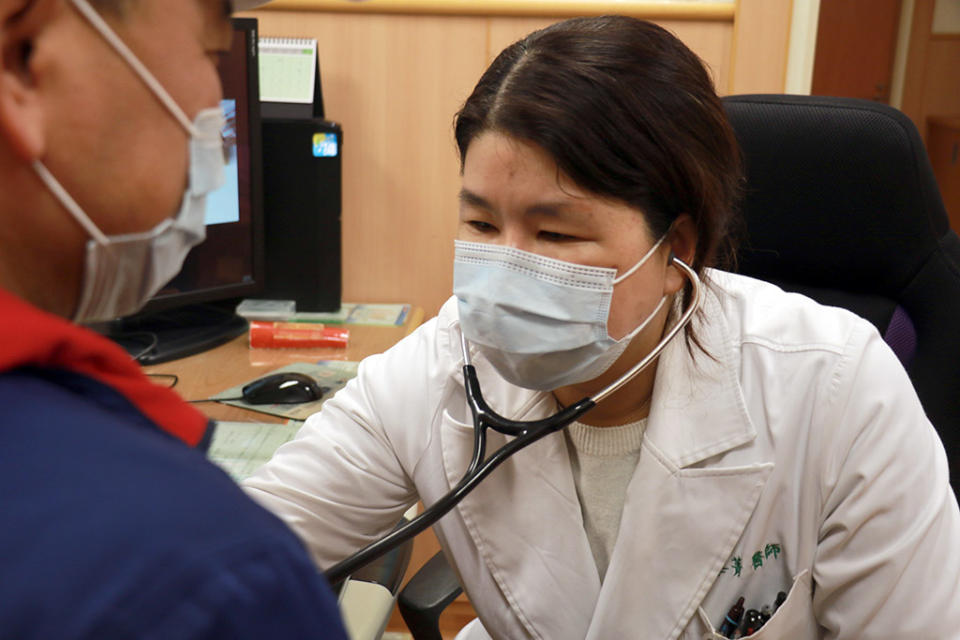 楊峯菁醫師（右）仔細聽診，了解郭先生心臟功能恢復情形。