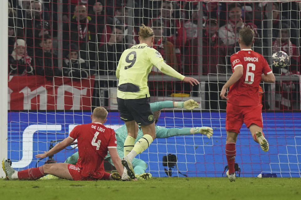 Manchester City's Erling Haaland, centre, scores his side's opening goal during the Champions League quarter final second leg soccer match between Bayern Munich and Manchester City, at the Allianz Arena stadium in Munich, Germany, Wednesday, April 19, 2023. (AP Photo/Matthias Schrader)