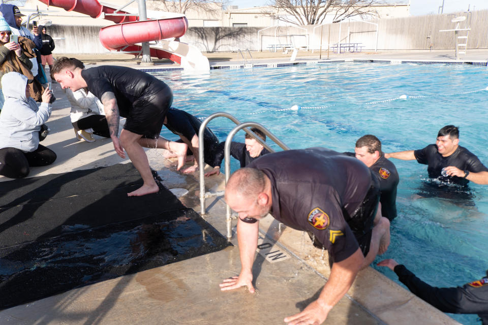 A couple of members of the Amarillo Police Department frantically get out of the pool at the Polar Plunge Saturday morning at the Amarillo Town Club.