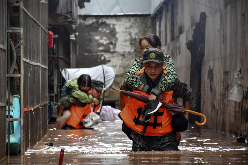 In this photo released by Xinhua News Agency, members of the Chinese People's Armed Police Force evacuate flood trapped residents in Wanzhou District, in southwest China's Chongqing Municipality, Tuesday, July 4, 2023. Heavy flooding has displaced thousands of people around China as the capital had a relative respite from sweltering heat. (Li Yuyang/Xinhua via AP)
