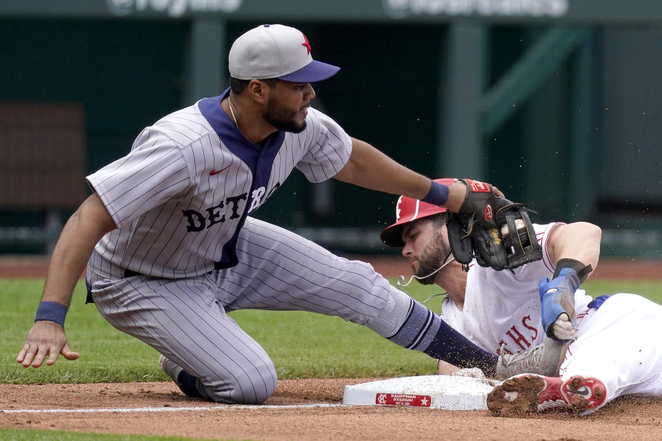 Kansas City Royals' Andrew Benintendi, right, is tagged out by Detroit Tigers third baseman Jeimer Candelario as he tried to steal third base during the fourth inning of a baseball game Sunday, May 23, 2021, in Kansas City, Mo. (AP Photo/Charlie Riedel)