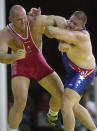 FILE - In this Sept. 27, 2000, file photo, Rulon Gardner, right, of the United States, holds the arm of Aleksandr Karelin, of Russia, during the final bout in the 130kg class of Greco-Roman wrestling event at the Summer Olympic Games in Sydney. Gardner is living a quiet life, just the way he likes it. He is 48 now, sells insurance and has a second job coaching wrestling at a Salt Lake City-area high school. It has been 20 years since Gardner, at 2,000-to-1 odds, beat three-time gold medalist Karelin in the Greco Roman heavyweight final at the Sydney games in one of the greatest upsets in sports history. (AP Photo/Katsumi Kasahara, File)