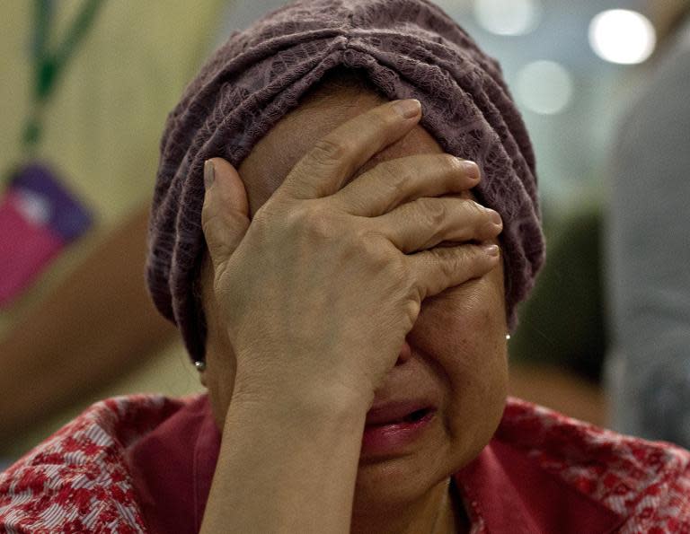 Akmar Binti Mohd Noor, 67, whose sister was onboard Malaysia Airlines flight MH17 from Amsterdam cries outside the family holding area at the Kuala Lumpur International Airport in Sepang on July 18, 2014