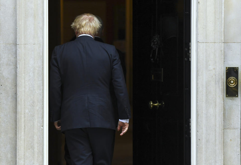 Britain's Prime Minister Boris Johnson walks back into 10 Downing Street after greeting U.S. Vice President Mike Pence in London, Thursday, Sept. 5, 2019. Boxed in by opponents and abandoned politically even by his own brother, Johnson struggled Thursday to keep his Brexit plans on track. (AP Photo/Alberto Pezzali)