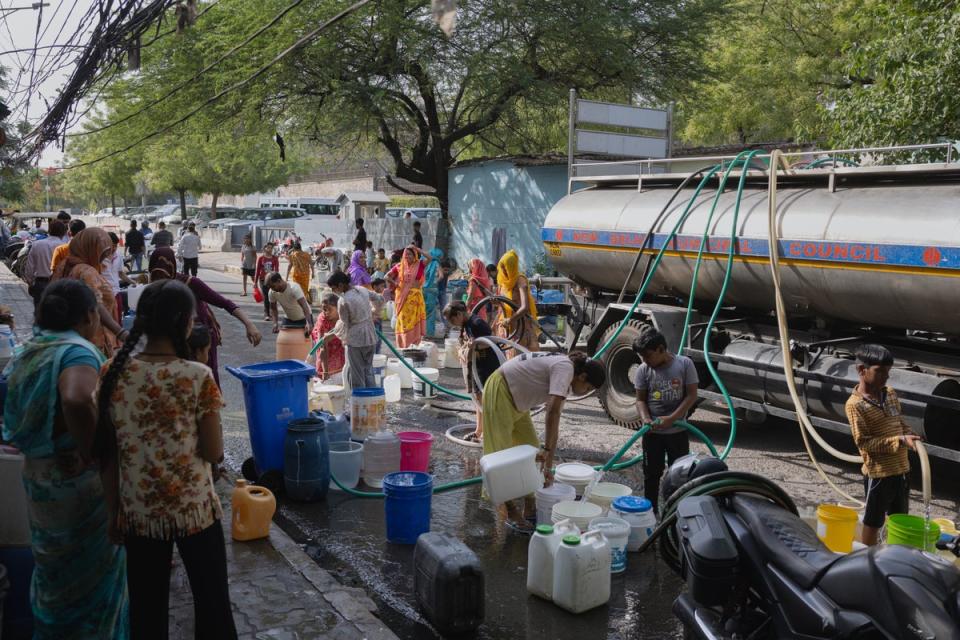 People queue up to fill buckets with water as heatwave prompts a water crisis in Delhi (Getty)