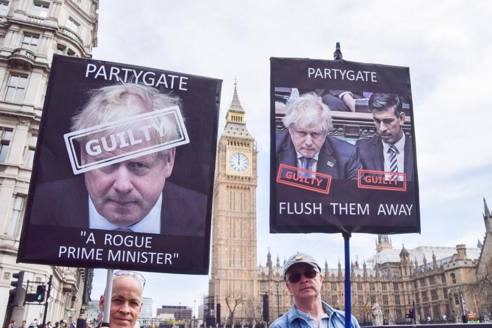 Protesters hold placards calling Boris Johnson and Rishi Sunak "guilty" over Partygate during the demonstration. Anti-Boris Johnson protesters gathered in Parliament Square as pressure mounts on the Prime Minister over the Partygate scandal.