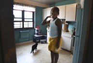 Mason Washington, 11, stands in the kitchen of his family's apartment after browsing the refrigerator for a mid-morning snack on Thursday, Aug. 13, 2020, in the Brooklyn borough of New York. The family has struggled to keep food in the cupboards during the pandemic: "It was hard feeding them three times a day," said Sharawn Vinson, his mother. (AP Photo/Jessie Wardarski)