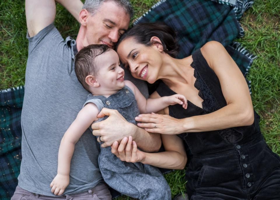 Tatiana Brenizer, with son Gavin, who had lead poisoning, and husband Ryan lying on a blanket.