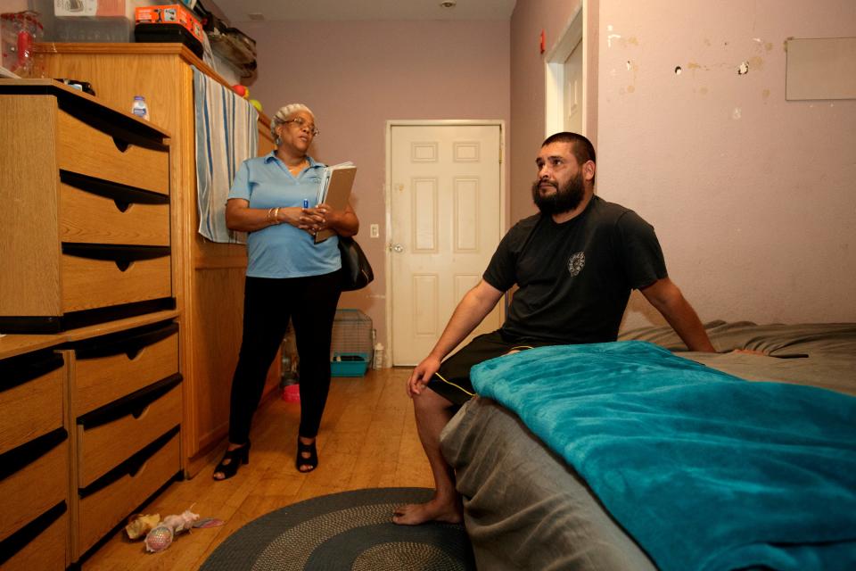 Sonya Gray-Hunn, left, listens as tenant Angel Villanueva talks about the difficulty of finding affordable housing as he and his seven family members will have to move from the unpermitted housing complex in San Bernardino, Calif., on October 5, 2022. 