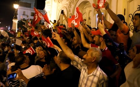 People react after exit poll results were announced in a second round runoff of the presidential election in Tunis