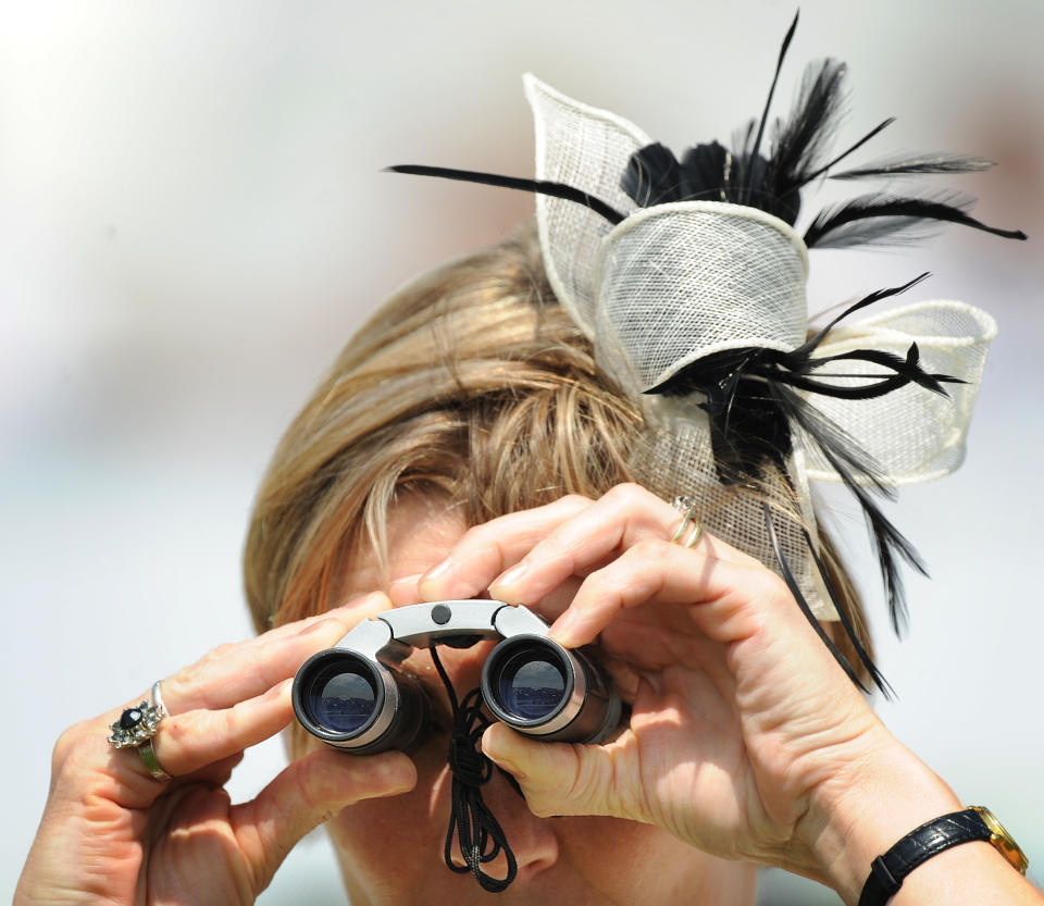 A racegoer looks through binoculars during Derby Day, the second day of the Epsom Derby, in Surrey, southern England on June 4, 2011. The Queen's horse, Carlton House, ridden by Ryan Moore, is seeking to be the first Derby winner owned by a reigning monarch since Minoru won in 1909 for King Edward VII. AFP PHOTO/ BEN STANSALL (Photo credit should read BEN STANSALL/AFP/Getty Images)