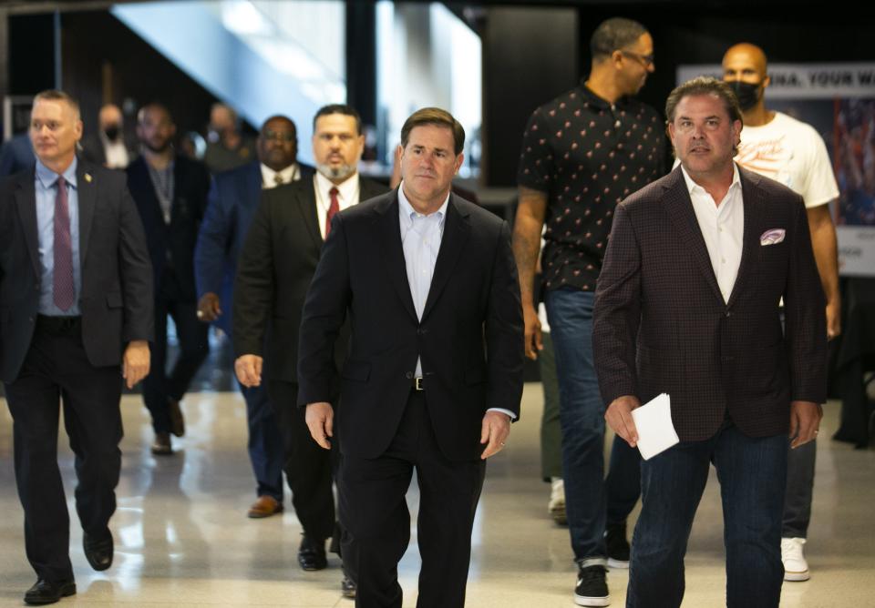 Gov. Doug Ducey and Phoenix Suns President and CEO Jason Rowley walk to a grand opening event at the FanDuel Sportsbook at the Footprint Center in Phoenix on Sept. 9, 2021.