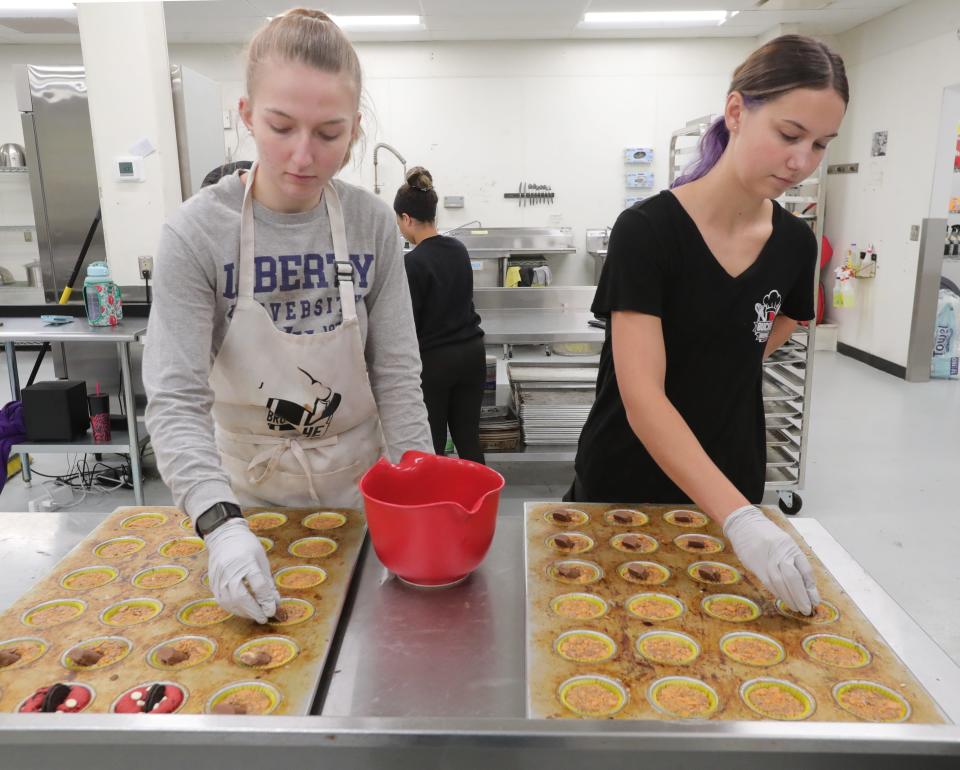 Buckeye Brownies workers Kiara Basford, left, and Annabelle Mighton put the finishing touches on pans of brownies Tuesday.