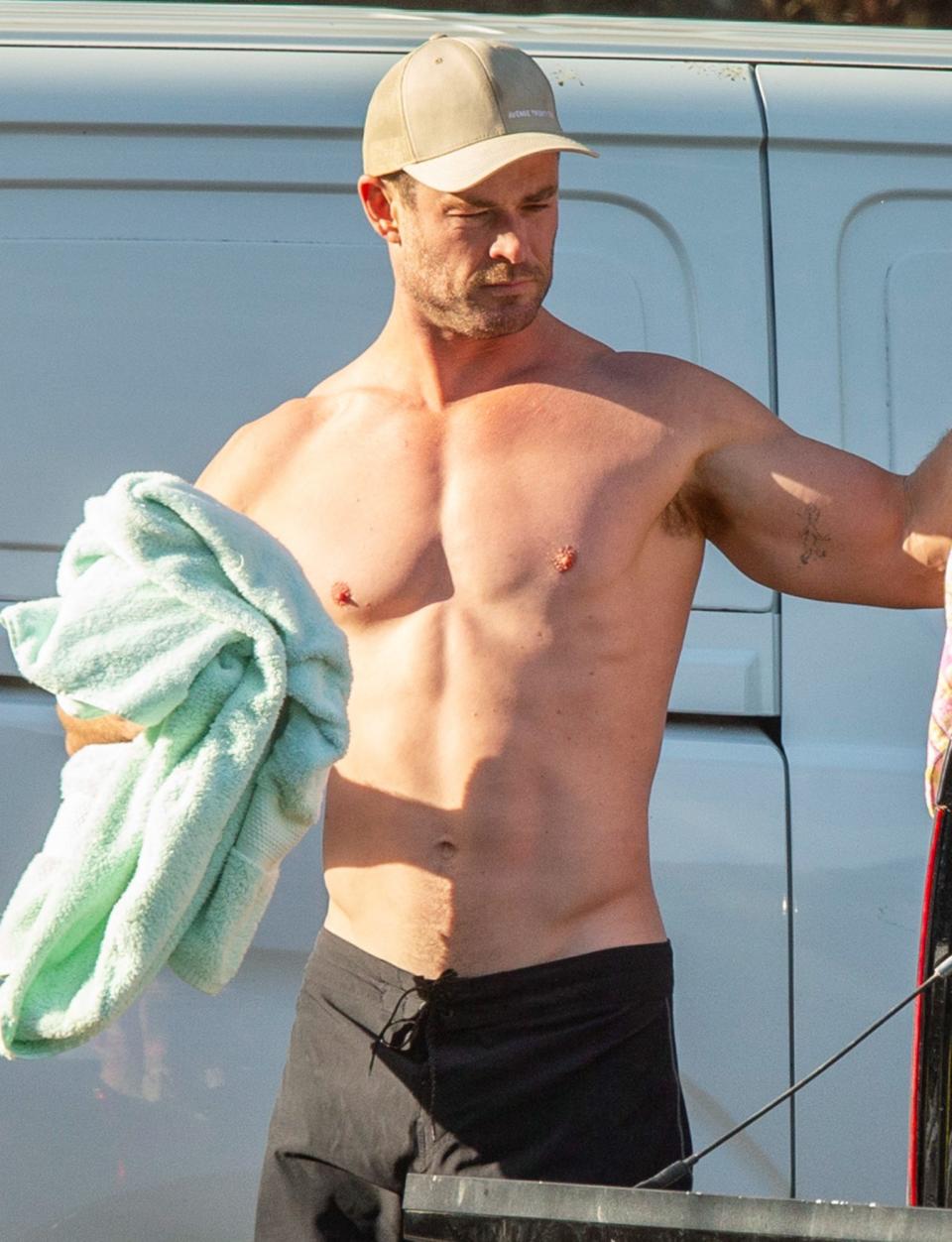 <p>Chris Hemsworth shows off his chiseled physique after hitting the beach in Byron Bay on Thursday. </p>