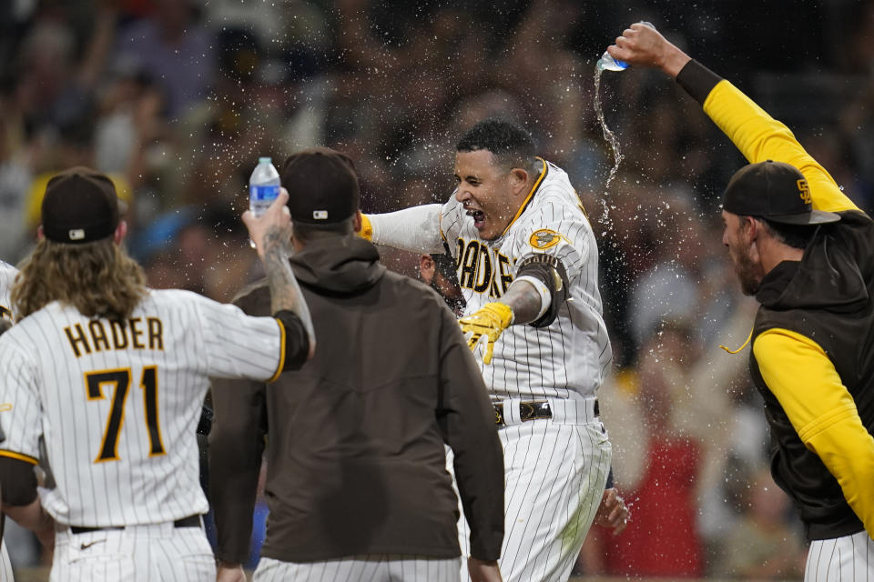 San Diego Padres' Manny Machado, second from right, celebrates with teammates after hitting a three-run home run during the ninth inning of the team's baseball game against the San Francisco Giants, Tuesday, Aug. 9, 2022, in San Diego. (AP Photo/Gregory Bull)