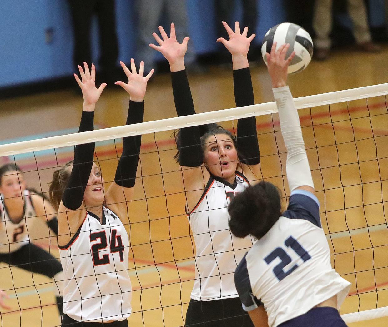 Kenston's Peyeton Pampush (21) tries to hit through the block of Marlington's Janelle Swisher (24) and Chelsea Evanich in a regional semifinal, Thursday, Nov. 2, 2023.