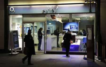 People pass an O2 store in central London November 24, 2014. REUTERS/Luke MacGregor