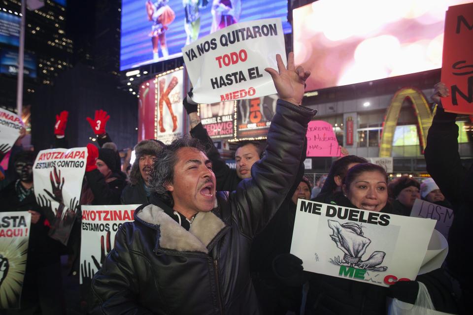 Protesters hold signs as they demonstrate against the Mexican government during U.S. President Barack Obama's speech on immigration reform, at Times Square in New York