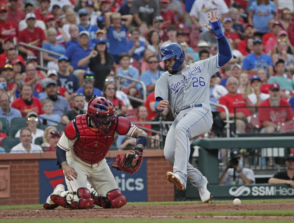 Kansas City Royals' Emmanuel Rivera (26) swerves to avoid St. Louis Cardinals catcher Yadier Molina, who is unable to catch the throw, to score in the fourth inning of a baseball game, aturday, Aug. 7, 2021, in St. Louis. (AP Photo/Tom Gannam)