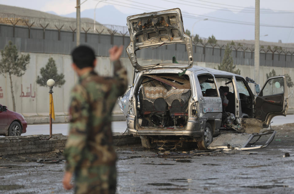 Security personnel inspect the site of a deadly bomb attack in Kabul, Afghanistan, Sunday, March 7, 2021. The bomb attached to minibus exploded Sunday in the capital, Kabul, killing and wounding several people. (AP Photo/Rahmat Gul)