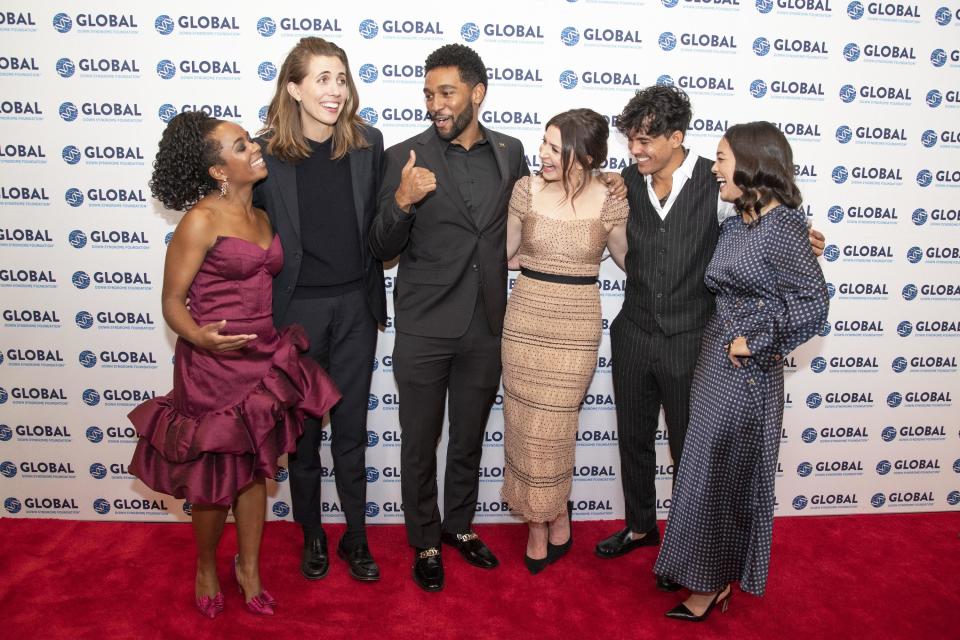 Caterina with her co-stars smiling on the red carpet