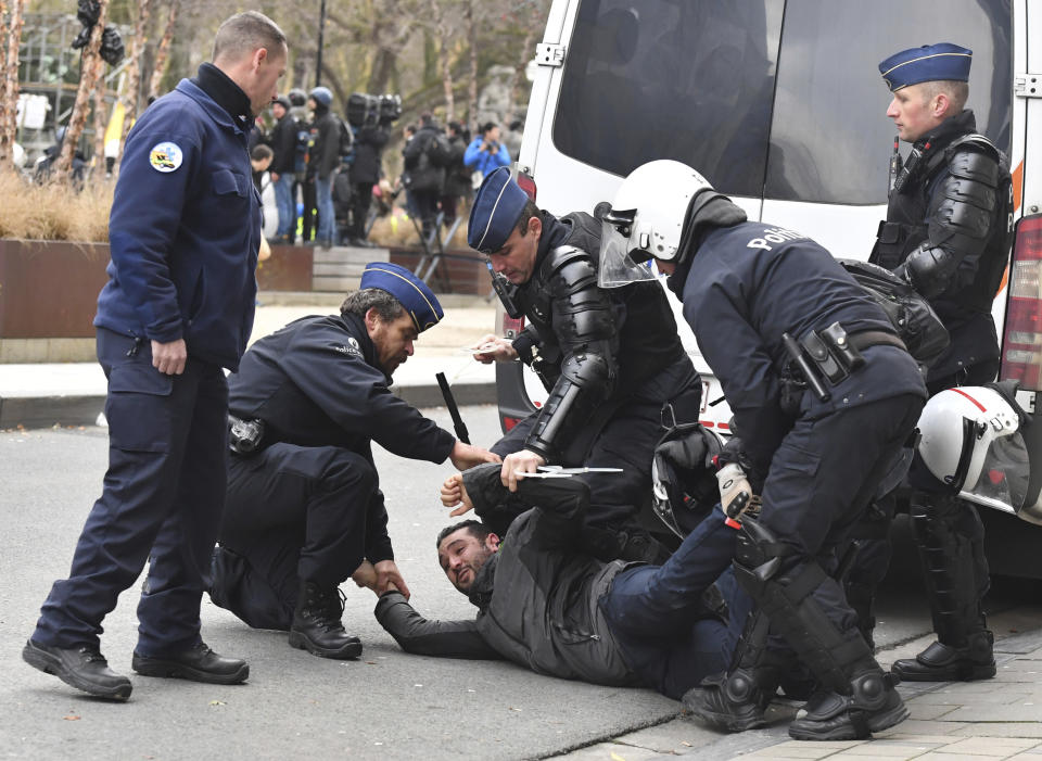 Police detain a protestor in the European Quarter during a demonstration in Brussels, Saturday, Dec. 8, 2018. Hundreds of police officers are being mobilized in Brussels Saturday, where yellow vest protesters last week clashed with police and torched two police vehicles. More than 70 people were detained. (AP Photo/Geert Vanden Wijngaert)