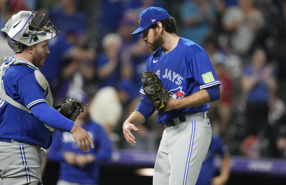 Toronto Blue Jays catcher Alejandro Kirk, left, congratulates relief pitcher Jordan Romano after the team's win in a baseball game against the Colorado Rockies on Friday, Sept. 1, 2023, in Denver. (AP Photo/David Zalubowski)