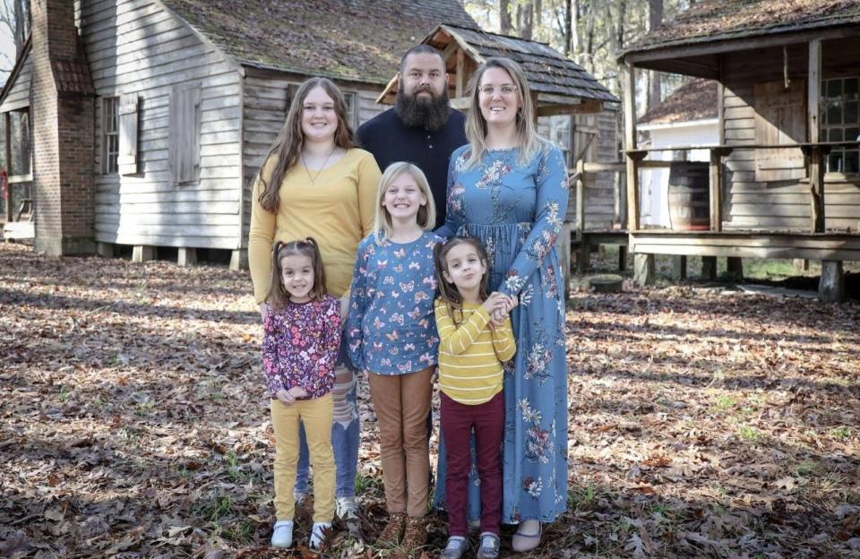 Andy Harville (center), his wife Kindall Harville, (right) and four daughters are photographed.