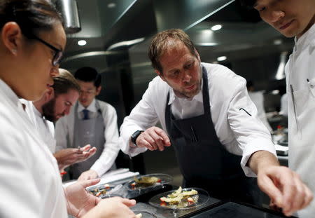 David Kinch (2nd R), the chef-owner of Manresa in Los Gatos in California, demonstrates plating dishes "Kisu, sillaginoid fish, and strawberry" at a kitchen during his special dinner event at a French restaurant Narisawa in Tokyo, Japan, July 9, 2015. Picture taken July 9, 2015. REUTERS/Yuya Shino