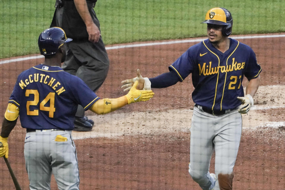 Milwaukee Brewers' Willy Adames (27) is greeted by Andrew McCutchen after he scored on a hit by Rowdy Tellez against the Pittsburgh Pirates during the second inning of a baseball game Wednesday, Aug. 3, 2022, in Pittsburgh. (AP Photo/Keith Srakocic)