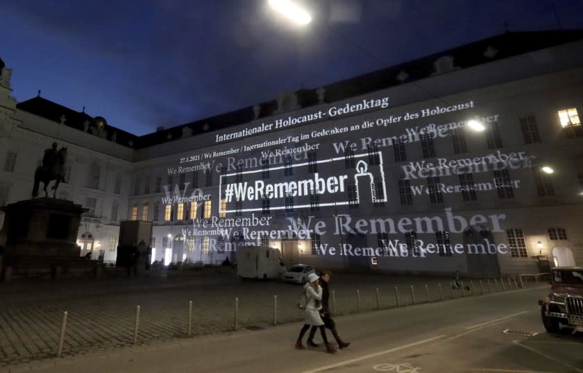 The words '#WeRemember' are displayed at the facade of the Austrian Parliament at the Hofburg palace in support of the campaign for the International Holocaust Remembrance Day in Vienna, Austria, Wednesday, Jan. 27, 2021. The anniversary of the liberation of the Nazi death camp Auschwitz is on Jan. 27, marking the International Holocaust Remembrance Day. (AP Photo/Ronald Zak)