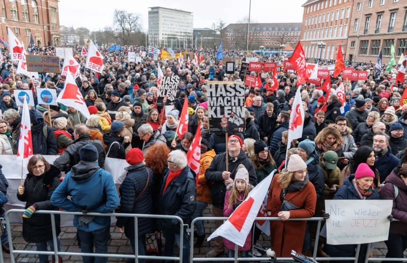 A demonstrator holds a sign reading "Hate makes you small" at a rally organized by the German Trade Union Confederation (DGB) on "For Democracy and Solidarity". Markus Scholz/dpa