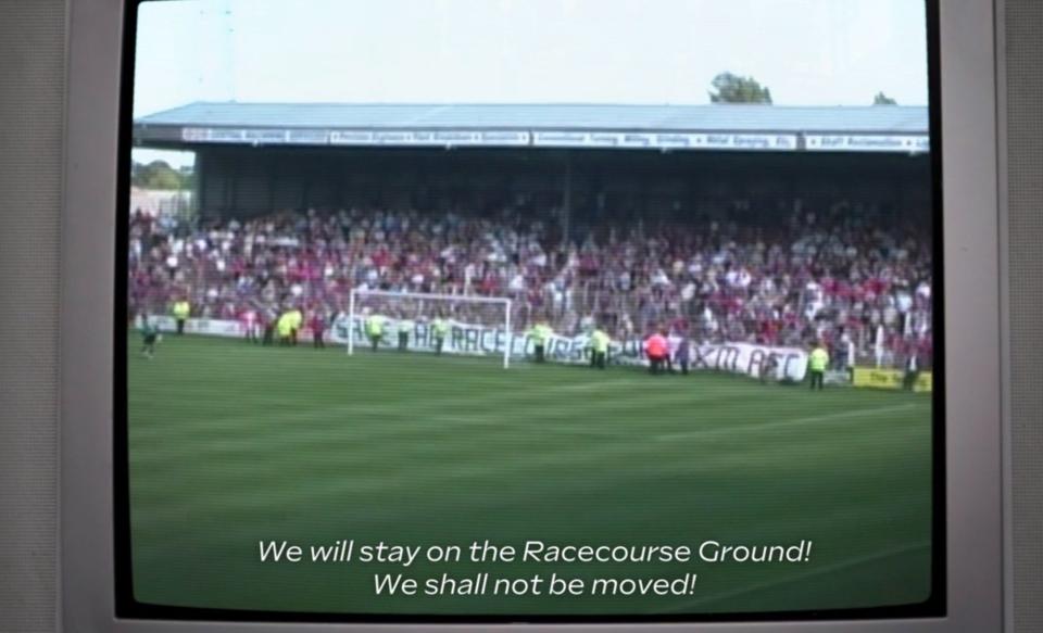 old footage of a Wrexham match with "SAVE THE RACECOURSE" banner across the pitch