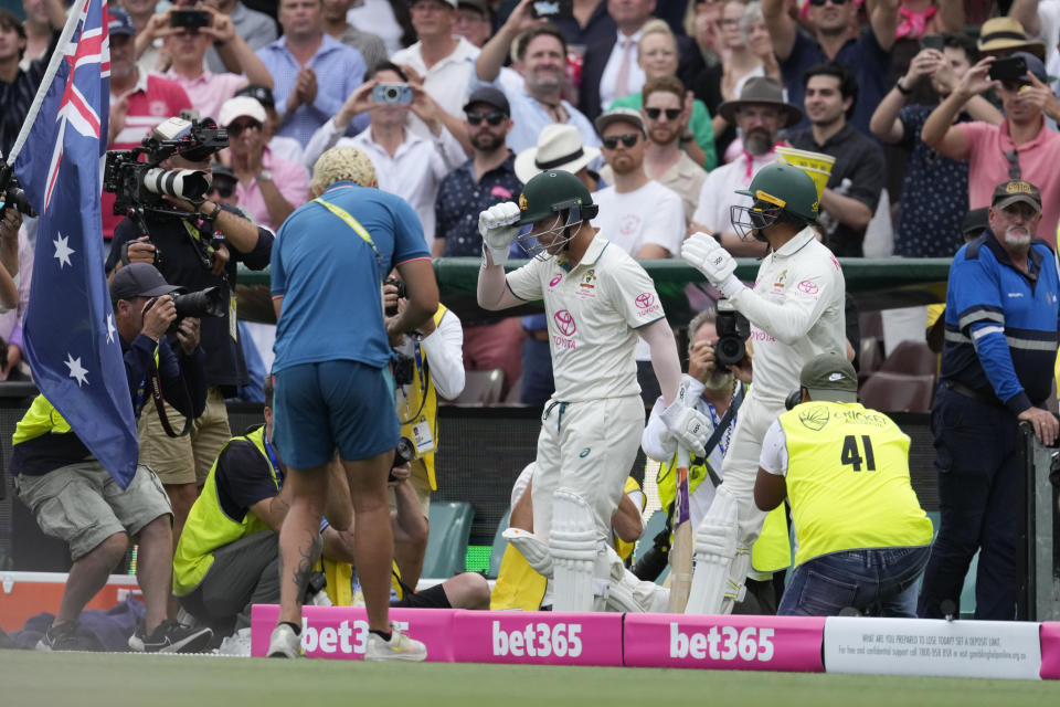 Australia's David Warner, center, walks out to open the batting in Australia's first innings against Pakistan during their cricket test match in Sydney, Wednesday, Jan. 3, 2024. (AP Photo/Rick Rycroft)