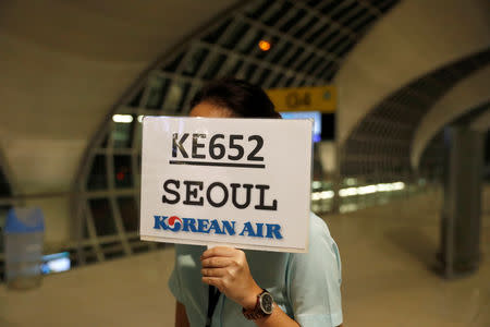 A woman holds a sign for Korean Air flight KE652 at Bangkok Airport, were Rahaf Mohammed al-Qunun, a Saudi woman is departing for asylum to Canada from Thailand January 11, 2019. REUTERS/Jorge Silva