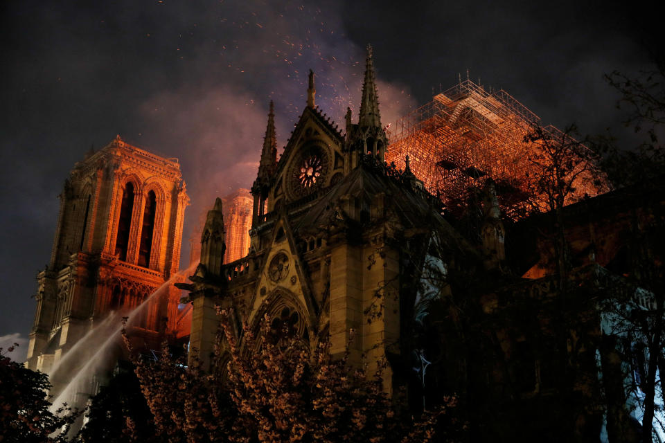 Sparks fill the air as Paris Fire brigade members spray water to extinguish flames as the Notre Dame Cathedral burns in Paris, France, April 15, 2019.   (Photo: Philippe Wojazer/Reuters)